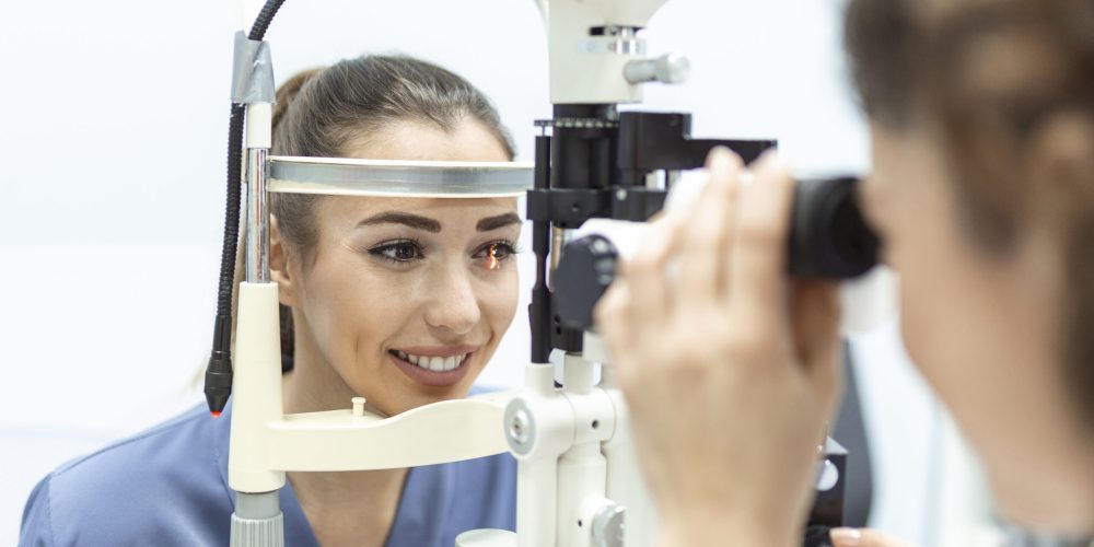 Eye doctor with female patient during an examination in modern clinic. Ophthalmologist is using special medical equipment for eye health Eye doctor with female patient during an examination in modern clinic. Ophthalmologist is using special medical equipment for eye health