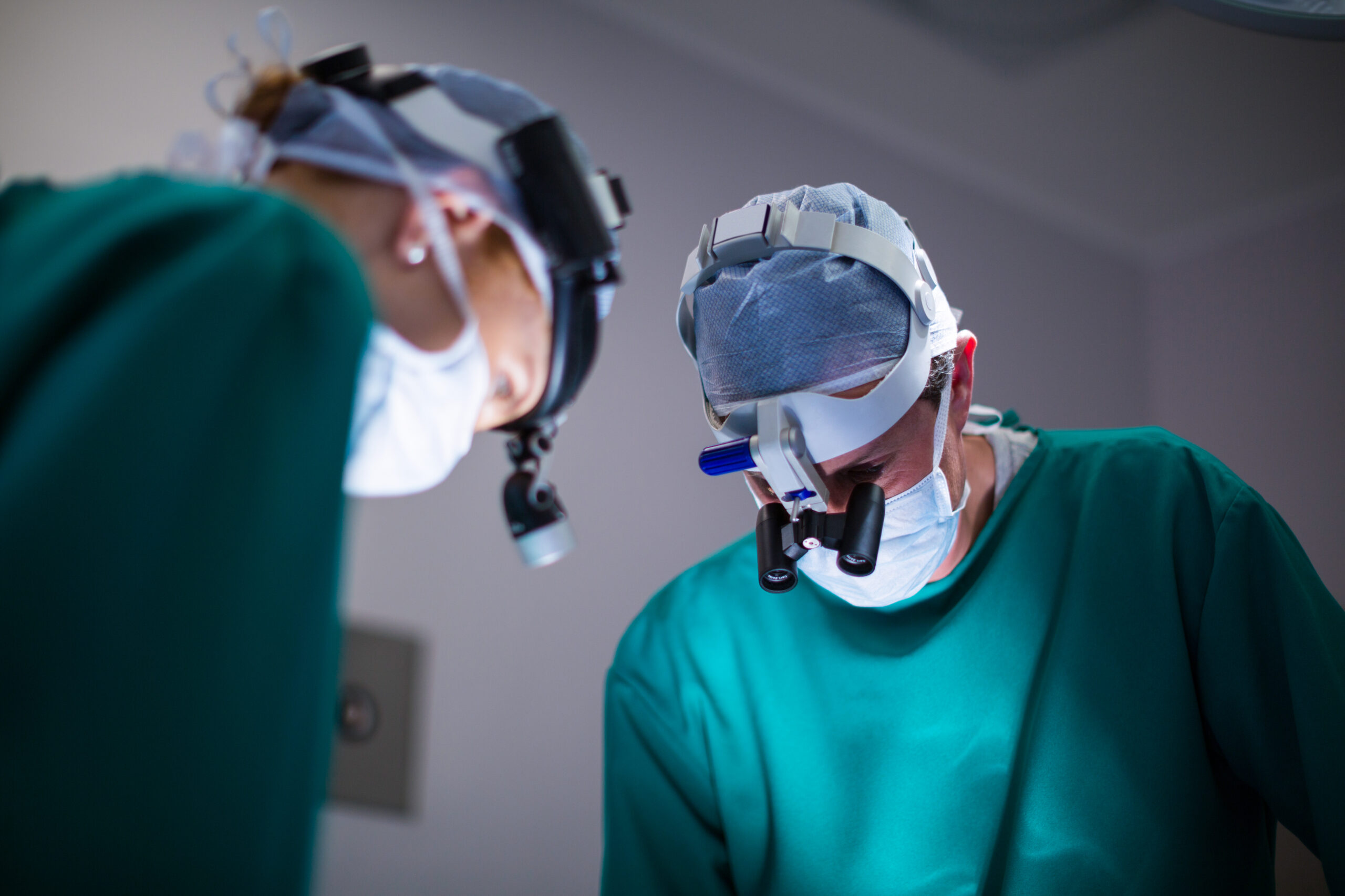 Surgeons wearing surgical loupes while performing operation in operation theater Surgeons wearing surgical loupes while performing operation in operation theater